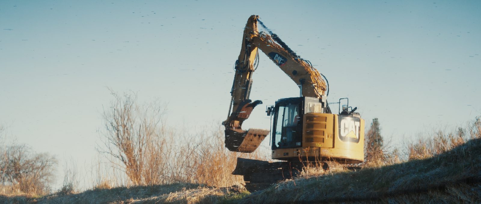 CAT excavator digging a dugout near Red Deer, Alberta