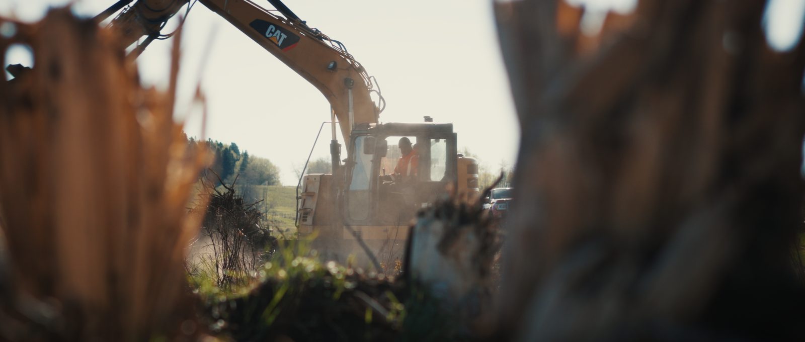 Excavator grading a roadside site near Red Deer, Alberta